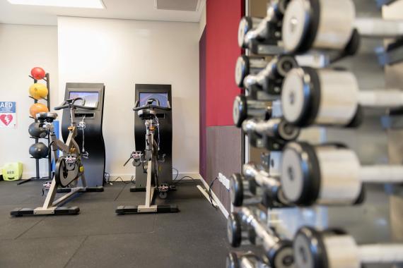 AIPM Venue - photo of gym with two bikes and dumbbell weights.